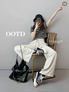 Woman in a striped crop top and wide leg pants sitting on a chair