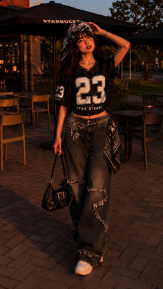 Woman in a bandana, crop top, and ripped jeans at golden hour