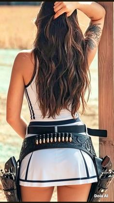 Woman with long hair, wearing a white skirt and cowboy belt with revolvers
