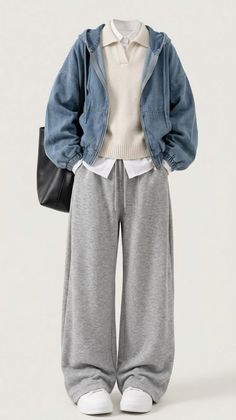 Full body shot of a person wearing a denim jacket, white sweater, and grey sweatpants
