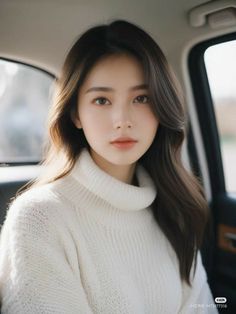 Woman with long hair wearing a white turtleneck in a car interior
