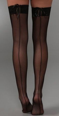 Woman's legs in black seamed stockings with lace tops