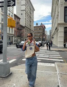 Woman in a crop top and baggy jeans walking on a city street