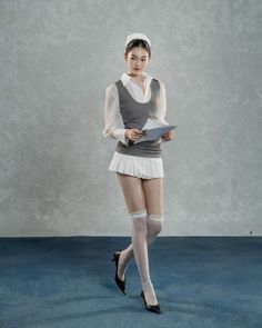 Woman in a white blouse, mini skirt, and thigh high stockings holding a paper