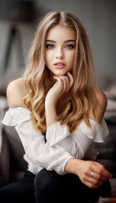 Woman with blonde hair and blue eyes wearing an off-shoulder top