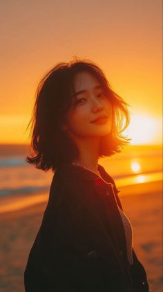 Woman with short hair on a beach at sunset with golden hour lighting