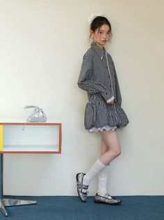 Woman in a striped dress and white socks standing indoors