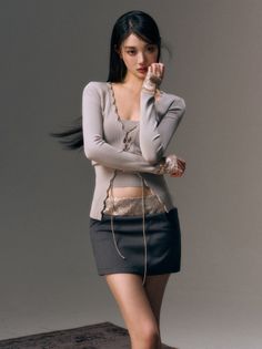 Woman with long black hair in a mini skirt and cropped top in a studio