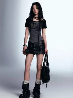 Woman with long black hair and glasses wearing a black leather skirt and boots