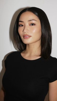 Woman with short black hair wearing a black t-shirt, looking at the camera