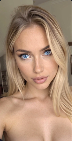 Blonde woman with blue eyes and freckles looking directly at the camera