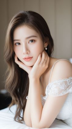 Woman with long brown hair wearing a white lace dress and pearl earrings