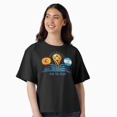 Woman in a black t-shirt with a graphic design featuring flags and a trophy