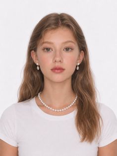 Young woman with long hair wearing a pearl necklace and earrings