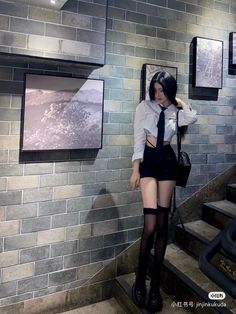 Woman in a cropped shirt and short shorts with thigh-high socks indoors