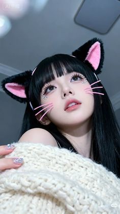 Woman with cat ears headband and sparkling makeup looking up