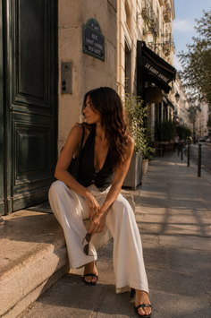 Woman with long hair sitting on stone steps in a city street at golden hour