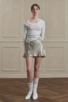 Woman in a sheer white top and mini skirt with white socks and heels