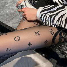Person wearing patterned tights and a zebra print top, holding a phone