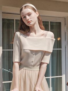 Woman with long hair and a headband wearing an off-shoulder top and tulle skirt