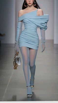 Woman in a light blue off-shoulder dress with sheer gloves and tights