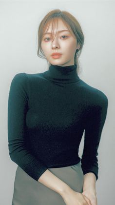 Woman in a black turtleneck with long hair and natural makeup