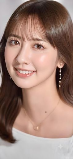 Close-up portrait of a smiling woman with long brown hair and bangs