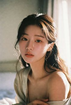 Woman with long hair and exposed shoulder in soft, warm lighting