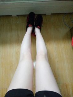 Person wearing black shorts and sneakers on a wooden floor
