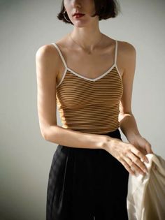 Woman with short hair wearing a striped top and black pants