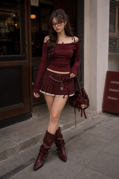 Woman in a plaid skirt and off-shoulder top with knee-high boots outdoors