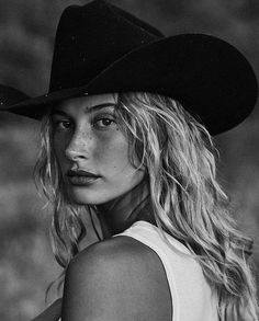 Woman with long blonde hair and a cowboy hat in a black and white portrait