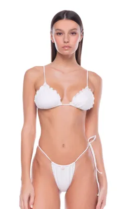 Woman in a white bikini posing against a white background