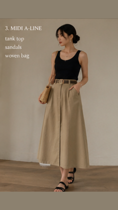 Woman in a black tank top and a midi A-line skirt with a woven bag