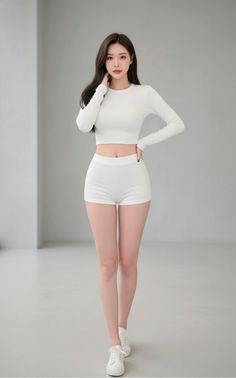 Woman in a white crop top and shorts posing indoors