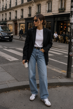 Woman in a black blazer and loose jeans standing on a city street