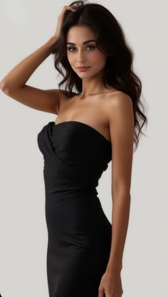 Woman in a black strapless dress posing in a studio