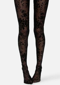 Pair of legs wearing black sheer tights with a floral pattern