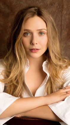 Woman with long blonde hair wearing a white shirt with cleavage