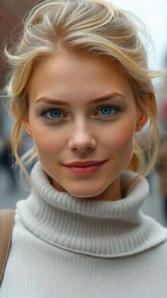 Blonde woman with blue eyes wearing a light-colored turtleneck sweater