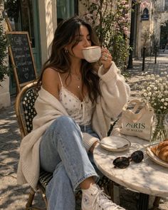 Woman drinking coffee at an outdoor cafe on a sunny day