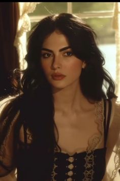 Woman with long dark hair wearing a corset with lace trim indoors