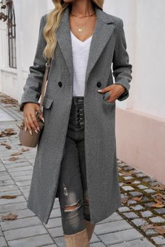 Woman in a long gray coat and ripped jeans on a paved street