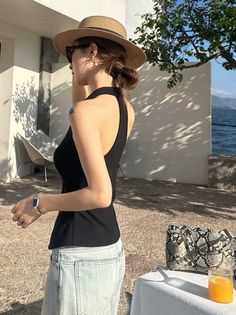 Woman in a straw hat and sunglasses by the water on a sunny day