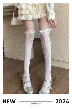 Person wearing white thigh-high socks with a ruffled mini skirt and silver shoes