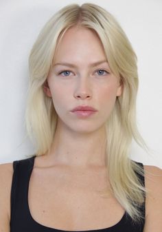 Woman with blonde hair and blue eyes wearing a black tank top