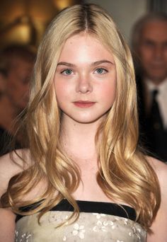 Young woman with blonde hair and blue eyes wearing a strapless floral dress