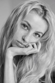 Close up black and white portrait of a woman with long blonde hair and freckles