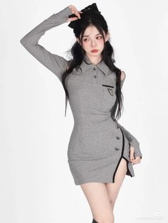 Woman with long black hair in a gray dress with a high slit