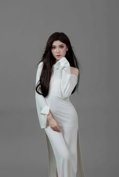 Woman with long black hair in a white off-shoulder dress in a studio